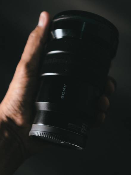 person holding black dslr camera lens